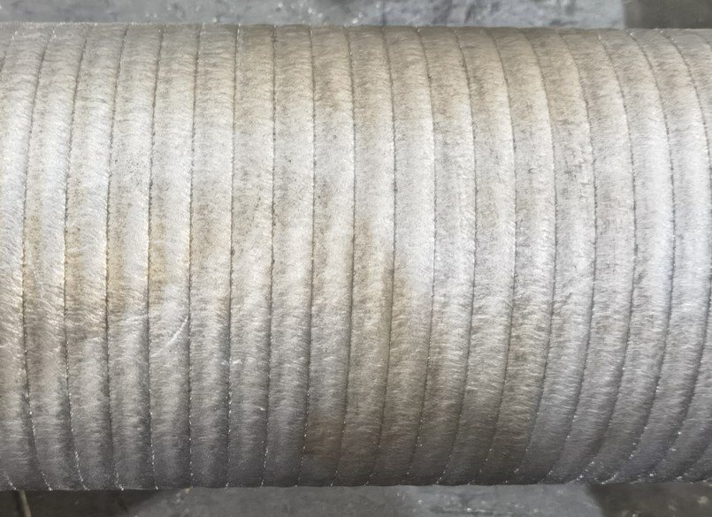 Wide-beam laser cladding result showing uniform deposition on metal component